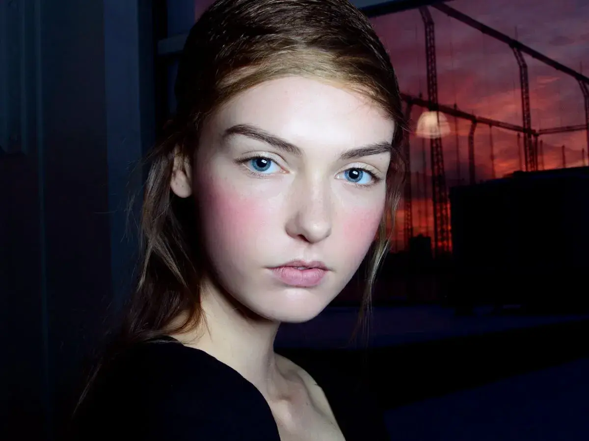 Ragazza con blush rosato sulle guance, un esempio di come scegliere il colore del blush per un look naturale.