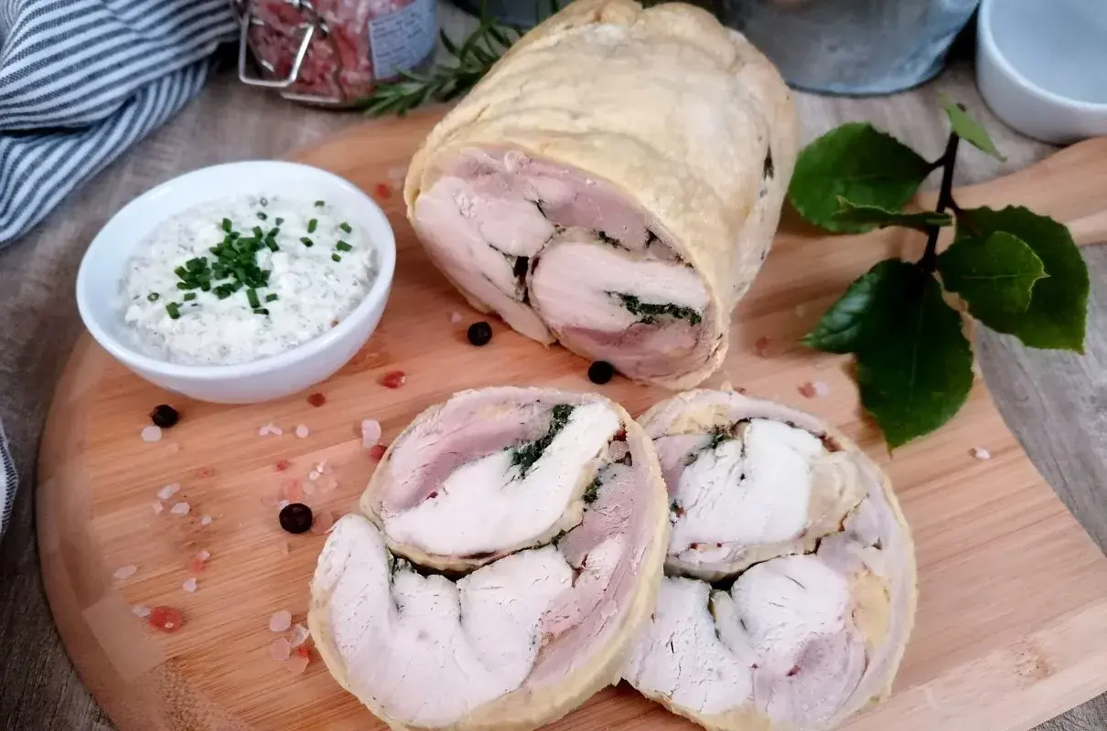 Galantyna z kurczaka, soczysta i aromatyczna, podana z kremowym sosem. Idealna na uroczysty obiad.
