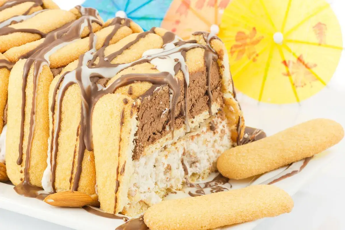 Delizioso zuccotto gelato, un tripudio di cioccolato e crema, decorato con savoiardi e mandorle. Perfetto per un'estate golosa!