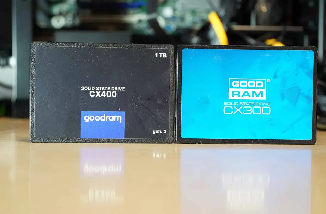 Dwa dyski SSD Goodram CX400 (1TB, gen. 2) i CX300 na błyszczącym blacie.
