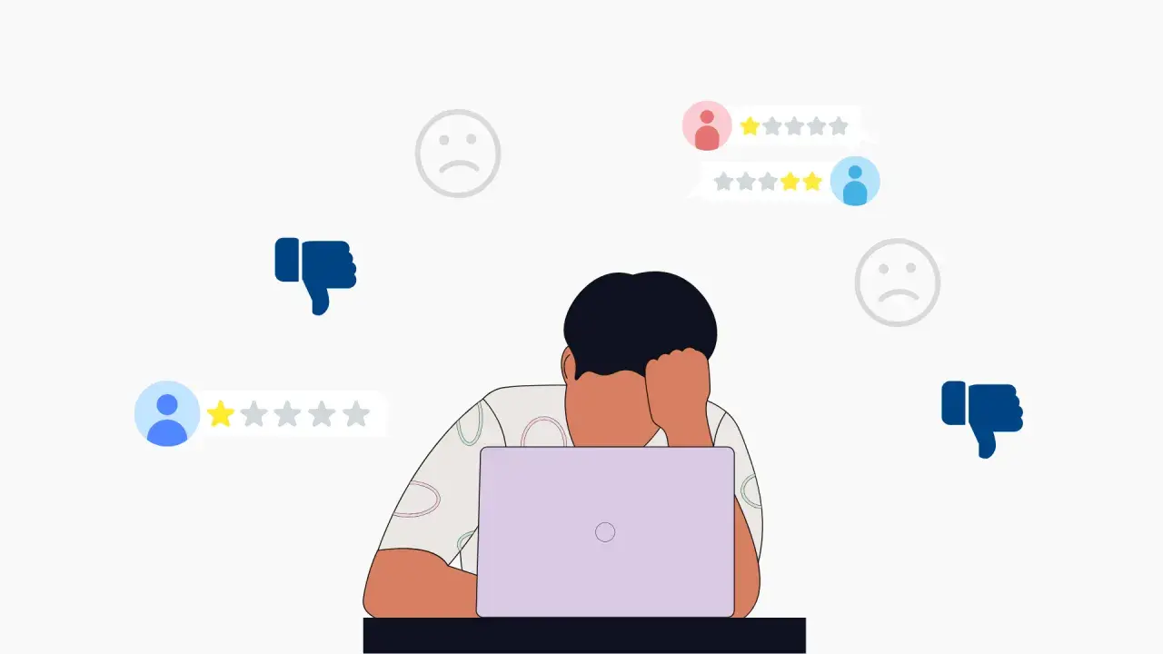Persona frustrata davanti al laptop, circondata da recensioni negative e pollici in giù. Impara come rispondere alle recensioni negative per migliorare la tua reputazione online.