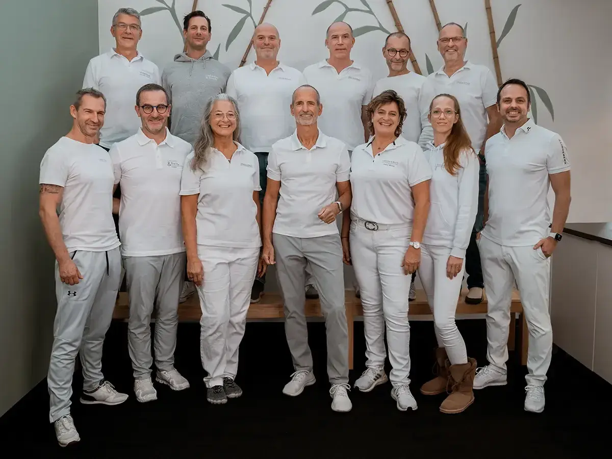 Teamfoto von Liebscher & Bracht. Die meisten tragen weiße Poloshirts und graue Hosen. Keine negativen Erfahrungen hier, nur ein motiviertes Team!