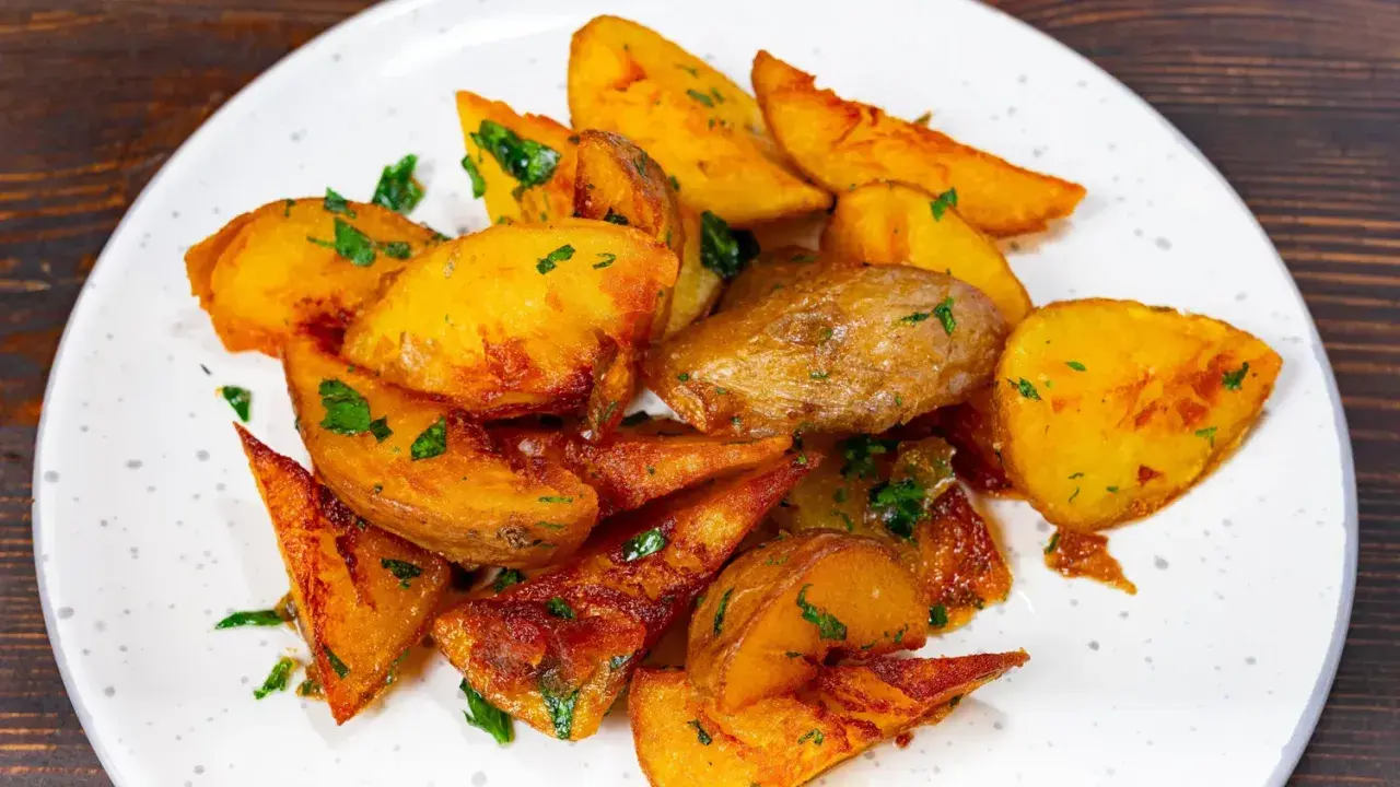 Pommes de terre rôties, coupées en quartiers et parsemées de persil frais. Une recette simple et savoureuse pour un accompagnement parfait.