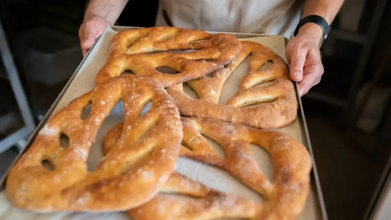 Une fougasse aux grattons feuilletée, dorée et croustillante, sort du four. Un délice à partager !