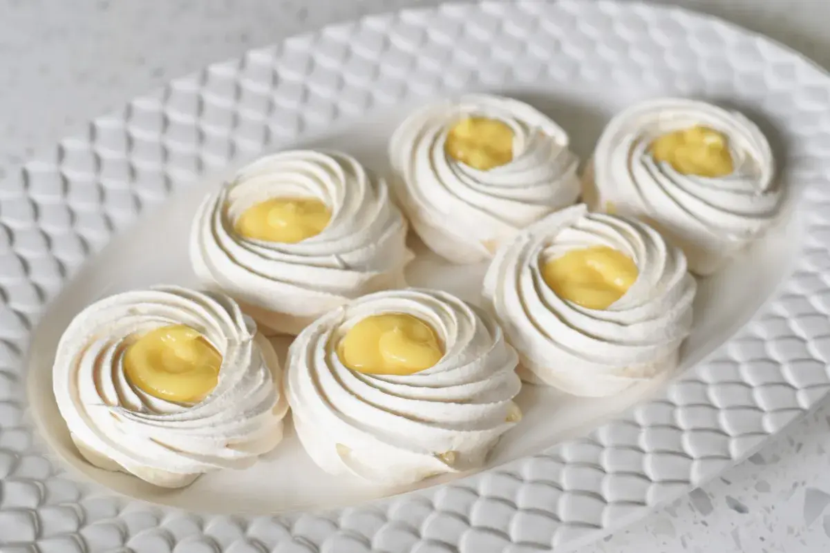 Små marängbottnar fyllda med krämig lemoncurd. Dessa pavlova med lemoncurd ser ljuvliga ut!