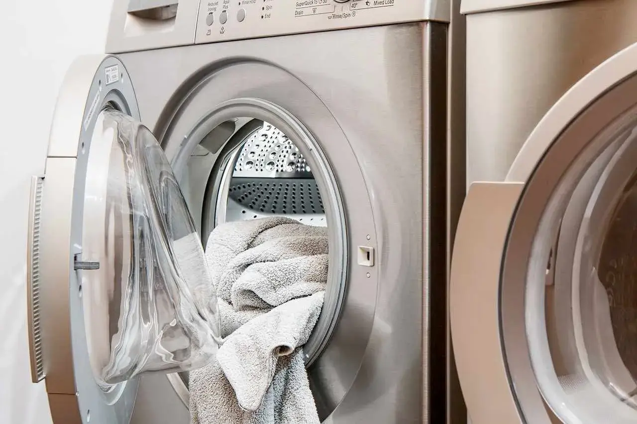 Pralka Beko z otwartymi drzwiczkami i włożonym ręcznikiem. Beko to znana marka sprzętu AGD.