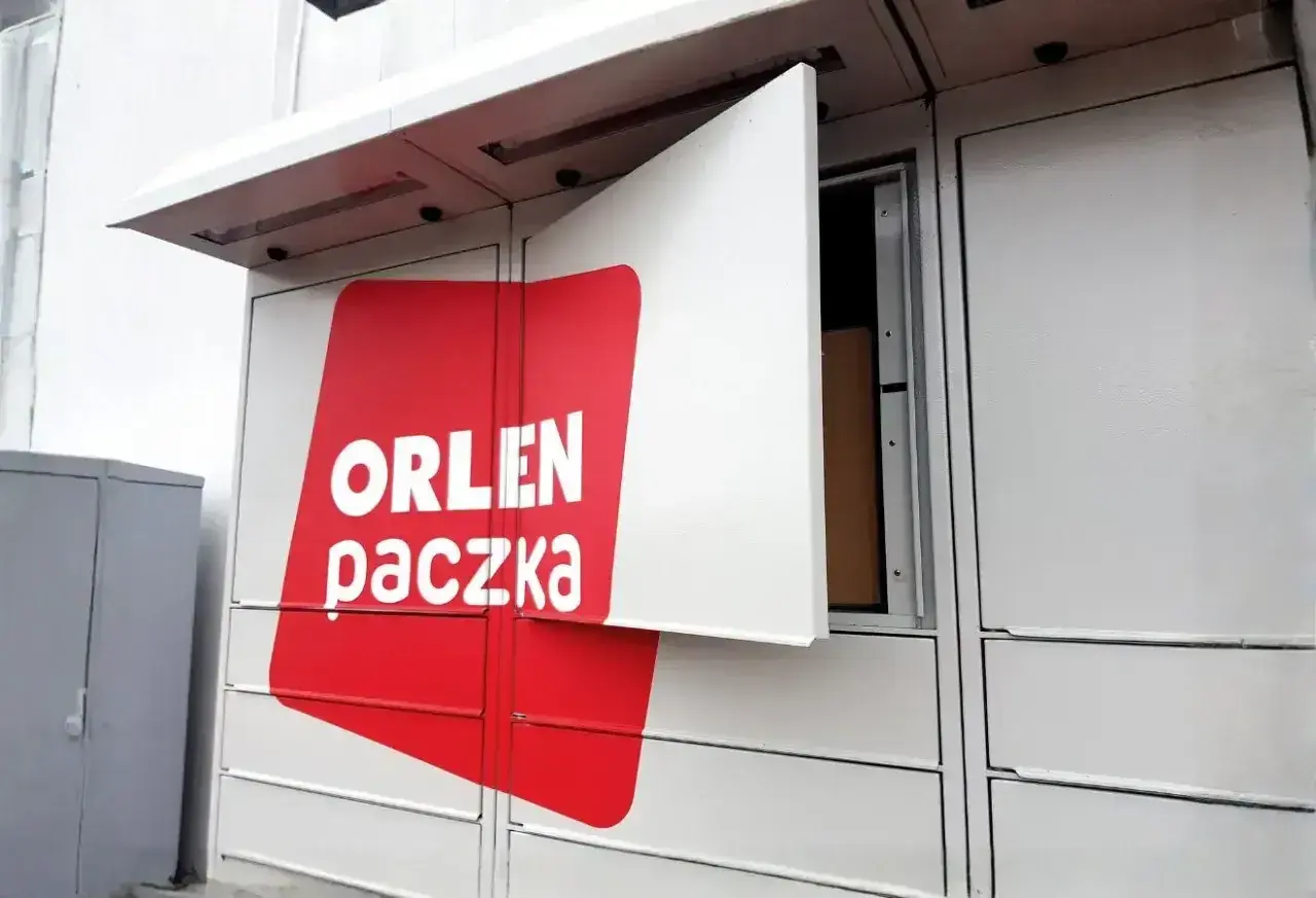 Automat paczkowy Orlen Paczka z otwartą skrytką, w której widać paczkę. Sprawdź orlen paczka wymiary przed nadaniem.