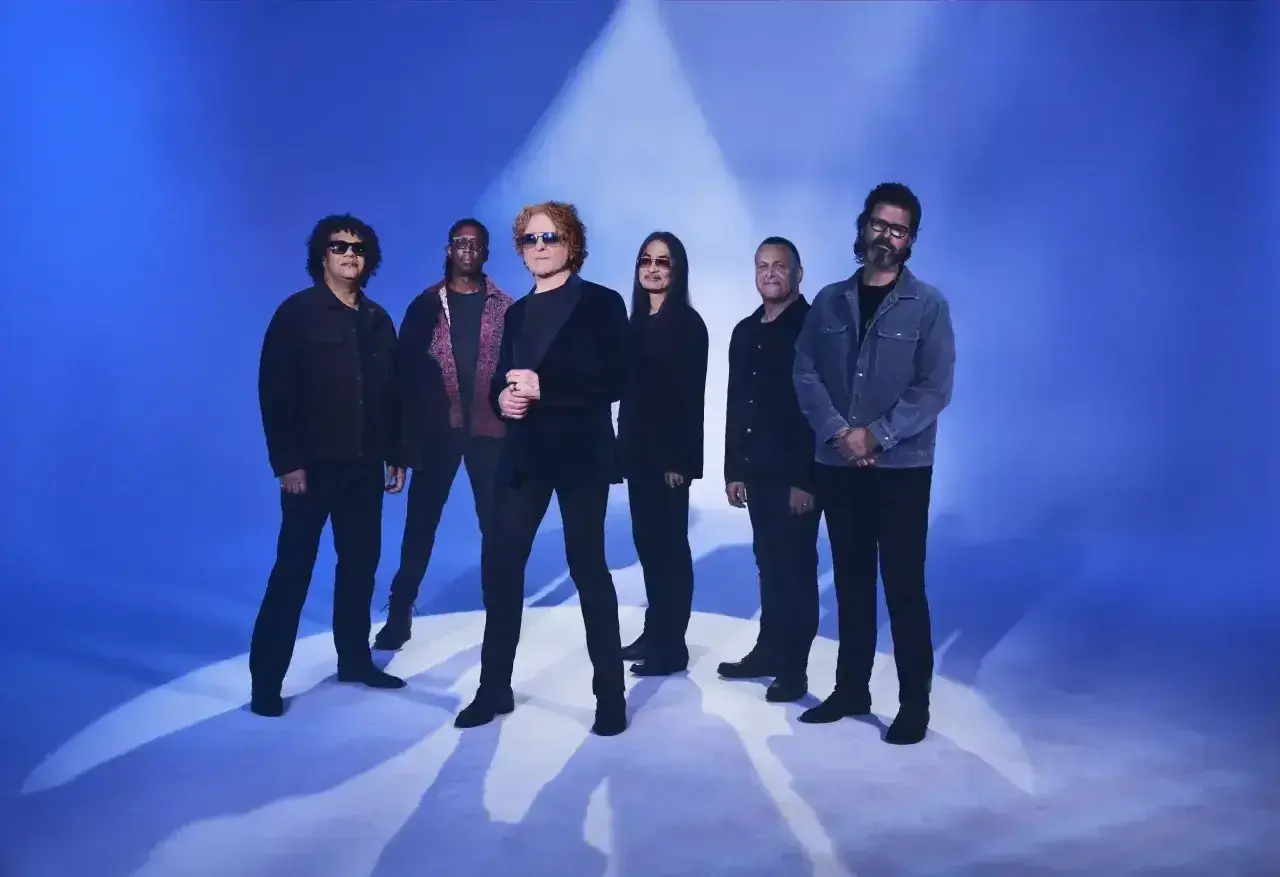 Zespół Simply Red na niebieskim tle, gotowy do koncertu.
