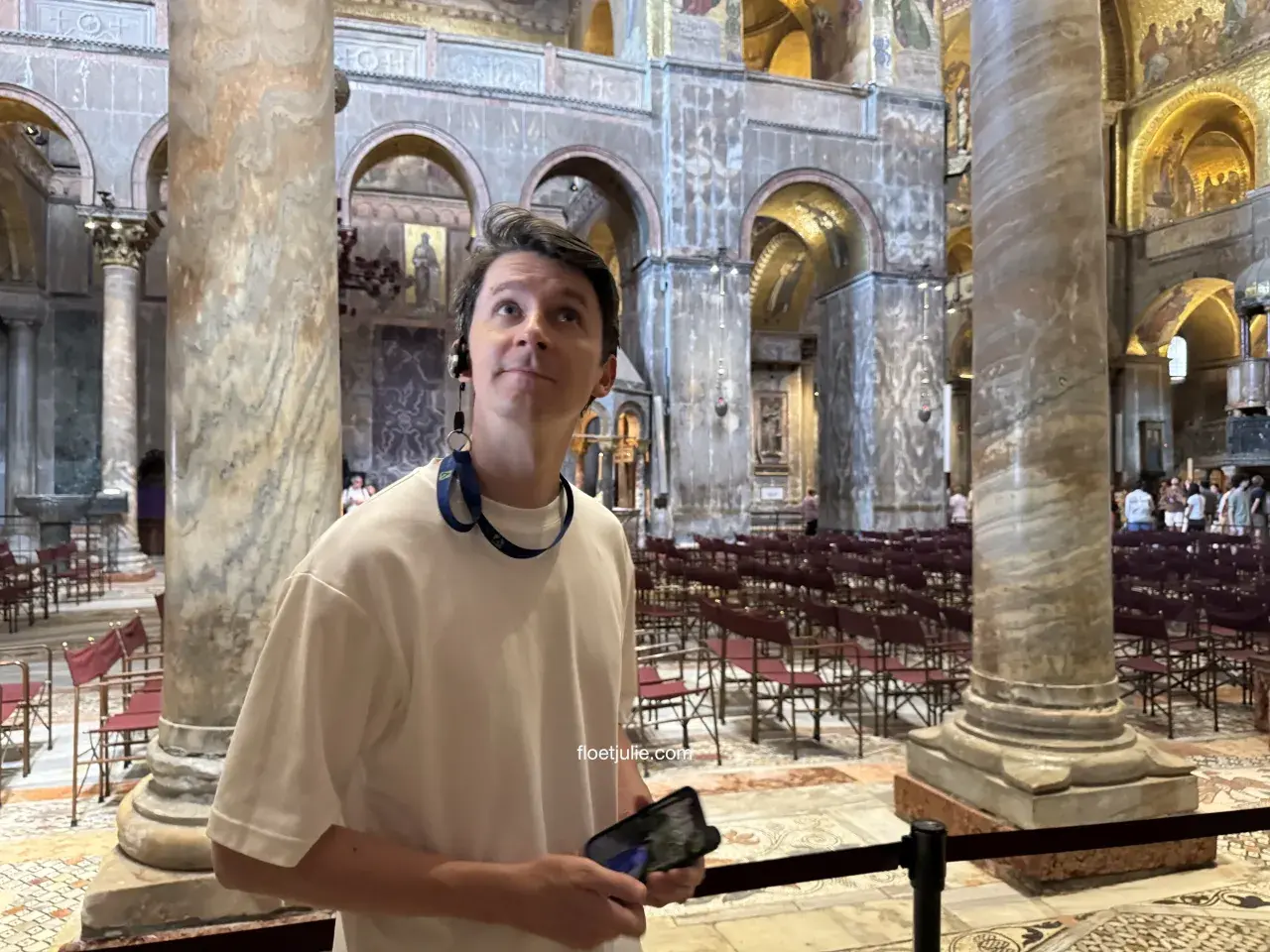 Un homme admire la splendeur de la basilique Saint-Marc, ses yeux levés vers les mosaïques dorées et les colonnes imposantes.