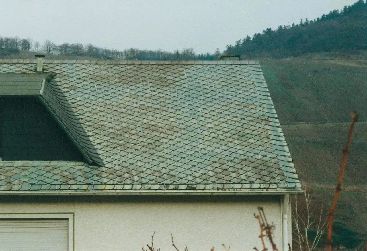 Dachziegel mit schuppenartiger Struktur, die auf Asbest hinweisen könnten. Vorsicht beim Umgang, um asbest dachziegel erkennen zu können.