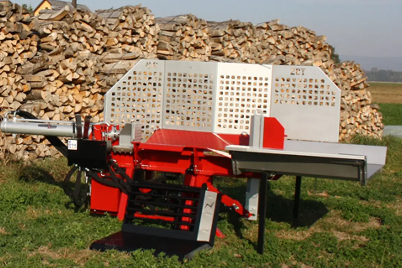 Roter Holzspalter mit 20T-Aufschrift, bereit für das nächste Holzspalter-Angebot. Im Hintergrund ein großer Stapel gespaltenes Holz.