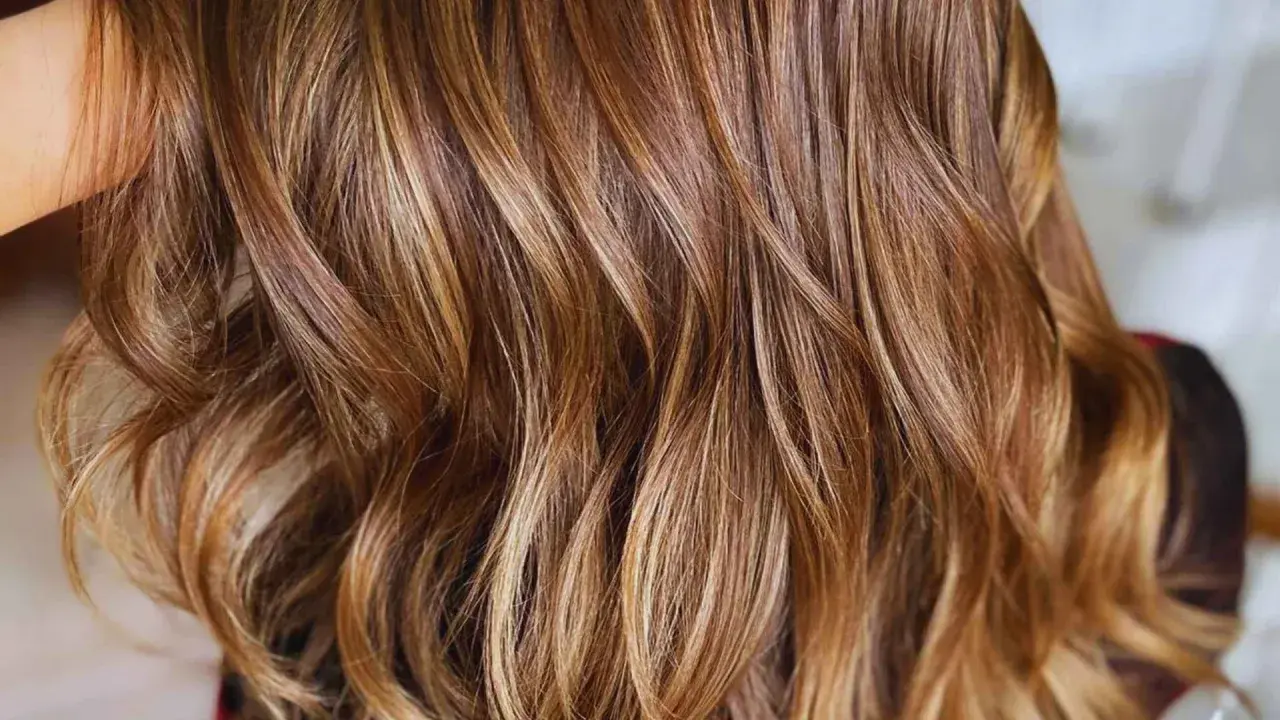Ondas suaves y brillantes con reflejos en pelo castaño, como si el sol jugara entre los mechones.