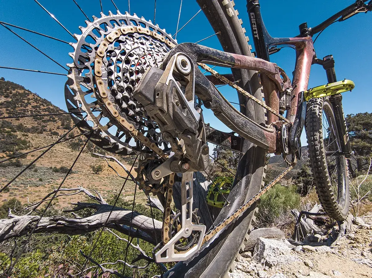 Close-up of a mountain bike's rear derailleur, showcasing its intricate design and the chain. This advanced electronic shifting system ensures smooth gear changes on challenging terrain.