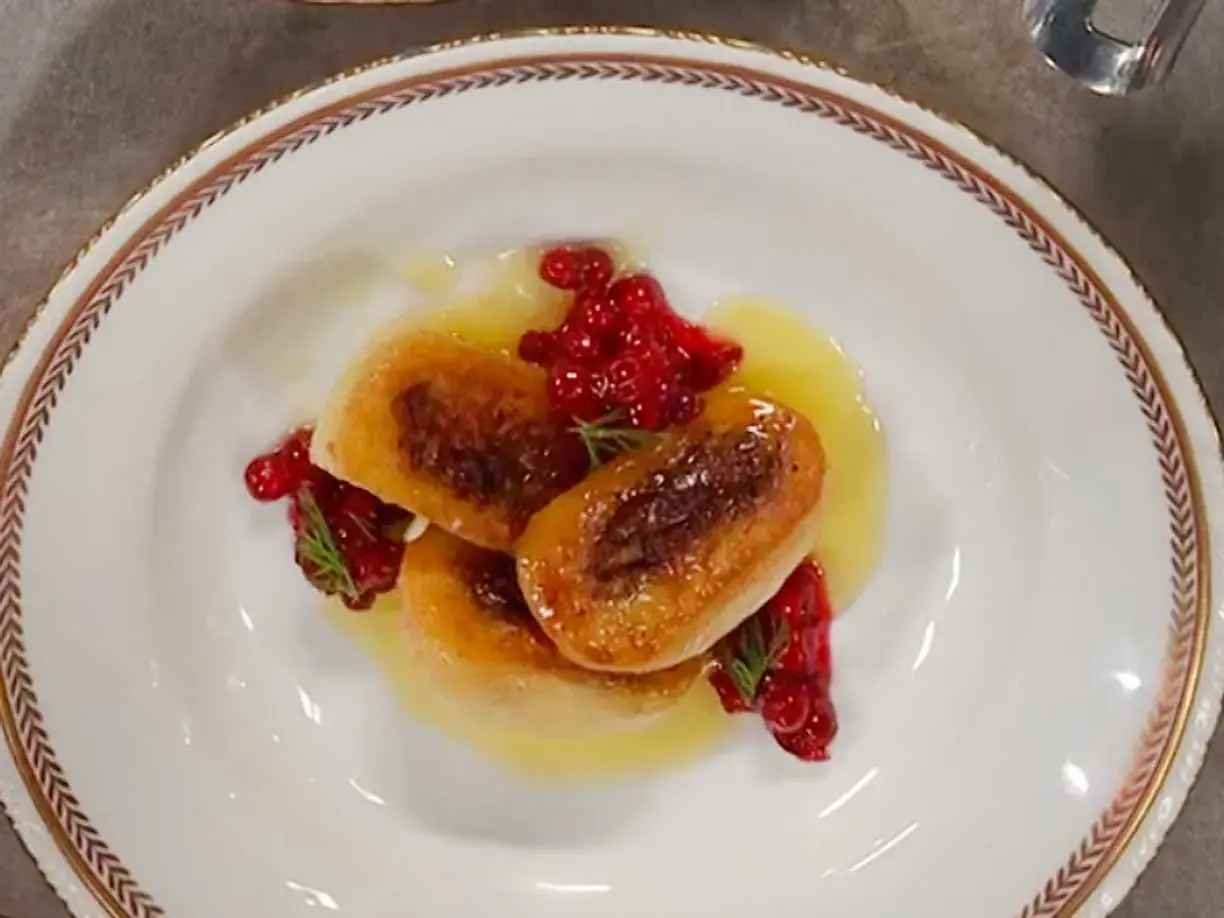 Tre gyllene kroppkakor serveras med lingon och en ljus sås. Ett vackert recept på kroppkakor!