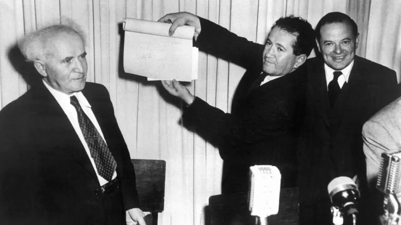 David Ben-Gurion hält ein Dokument hoch, das die Gründung Israels 1948 markiert.