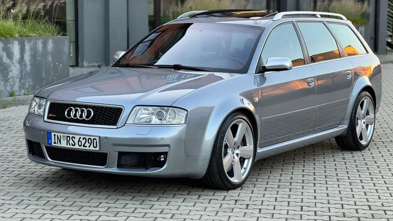 Srebrne Audi RS6 C5 Avant na kostce brukowej, z odbiciem zachodzącego słońca na karoserii.