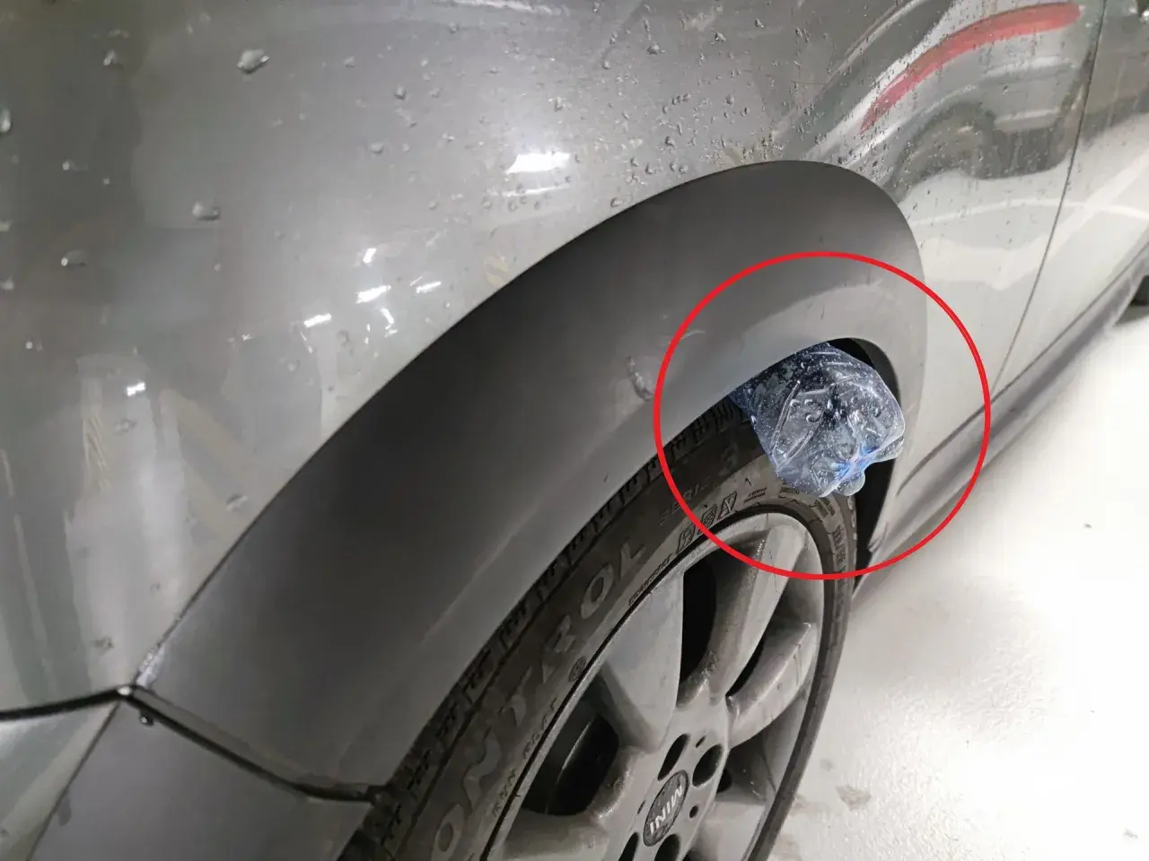 Plastikowa butelka utknęła w nadkole samochodu, tworząc nietypową ozdobę.