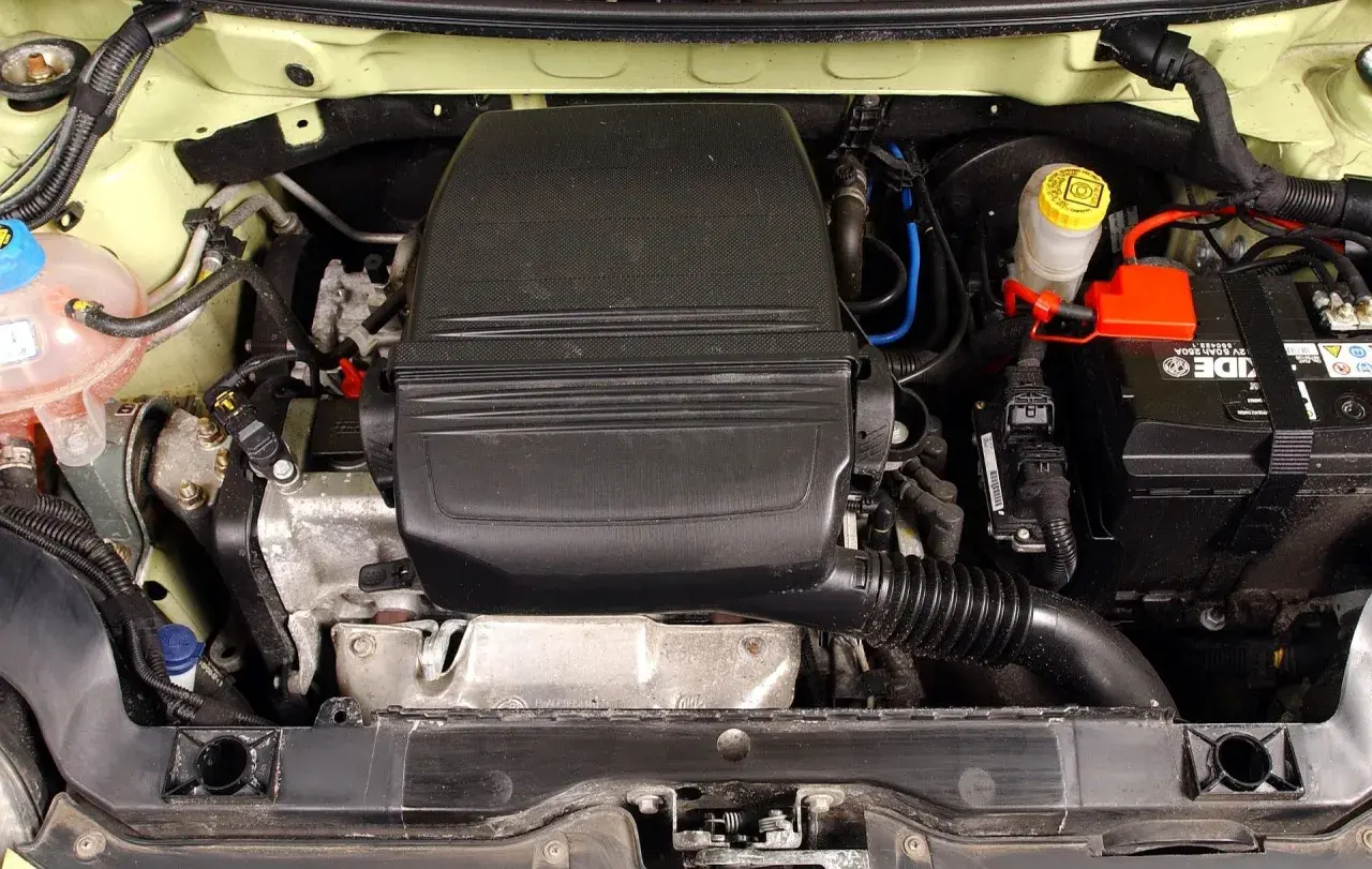 Silnik fiat panda 2, widok z góry. Widać akumulator, zbiorniczek płynu hamulcowego i osłonę silnika.