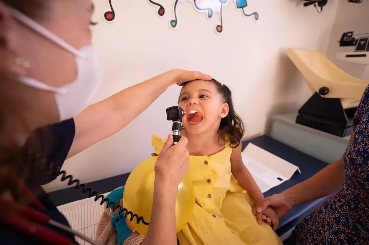 Bambina con gola esaminata da pediatra. Chissà quanto guadagna una pediatra al mese per curare i nostri piccoli.