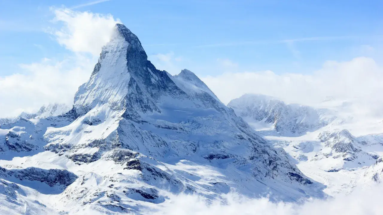 Majestatyczny szczyt Matterhorn, korona Europy, w otoczeniu innych ośnieżonych gór.
