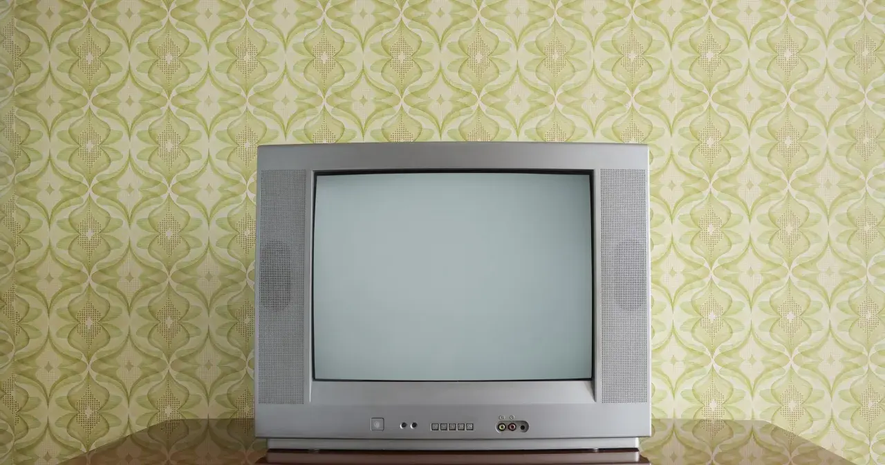 Stary kineskop na tle tapety w zielone wzory. Czekał na ulubiony program.