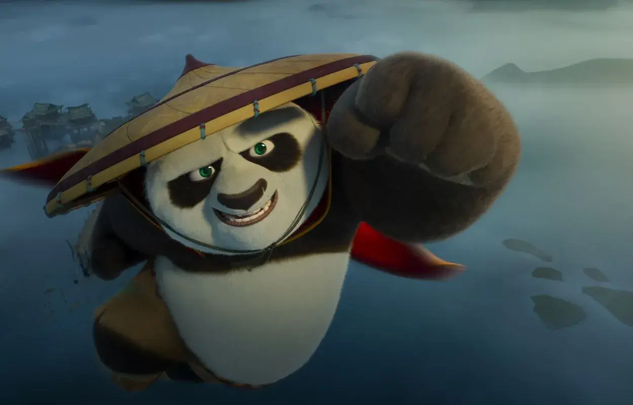 Po, med sin ikoniska hatt, flyger framåt med en knuten näve redo. En scen från rollistan i Kung Fu Panda 4.