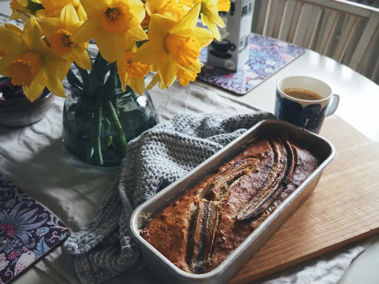 Nybakad banankaka, kanske från Sofia Wood, med kaffe och påskliljor. En mysig fika.
