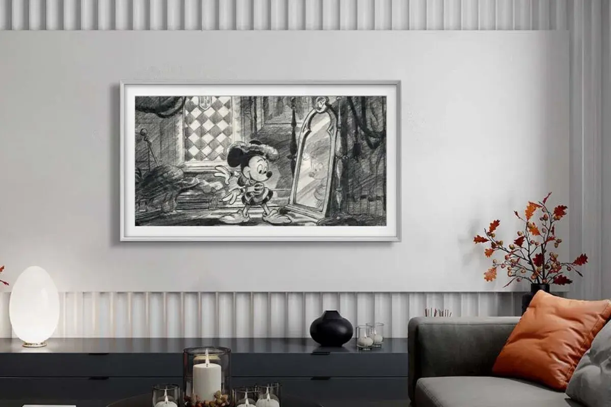 Mickey Mouse blickt in einen Spiegel. Ein moderner Fernseher, der wie ein Bild aussieht, hilft, Technik im Wohnzimmer zu verstecken.