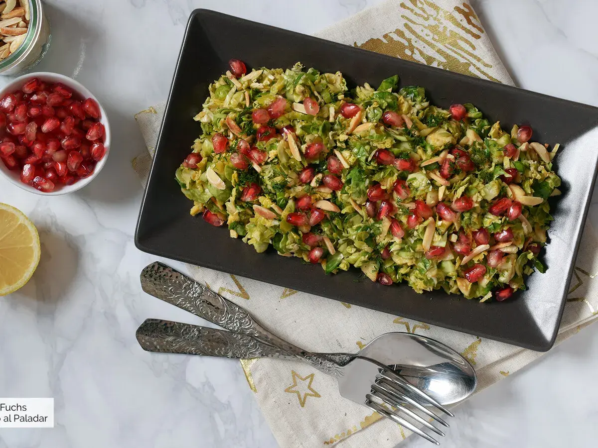 Ensalada de col con granada y almendras laminadas, un plato fresco y vibrante.