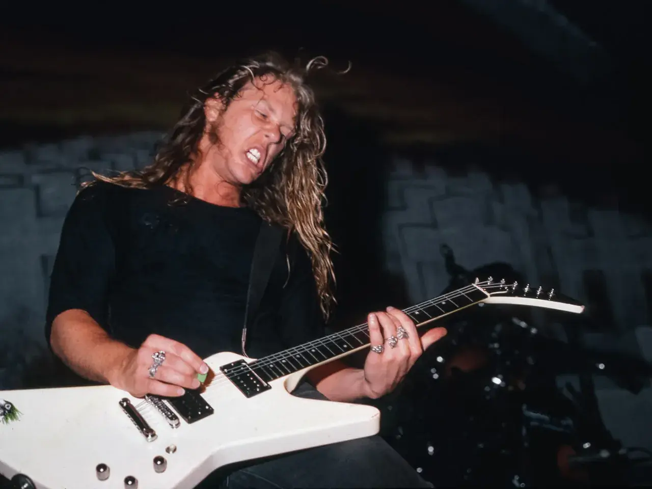 James Hetfield z Metalliki gra na białej gitarze typu Flying V.