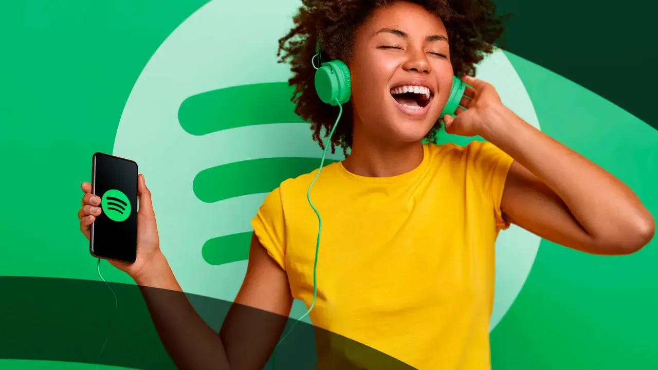 A woman with headphones sings along to music from her phone, showcasing the joy of Spotify social media.