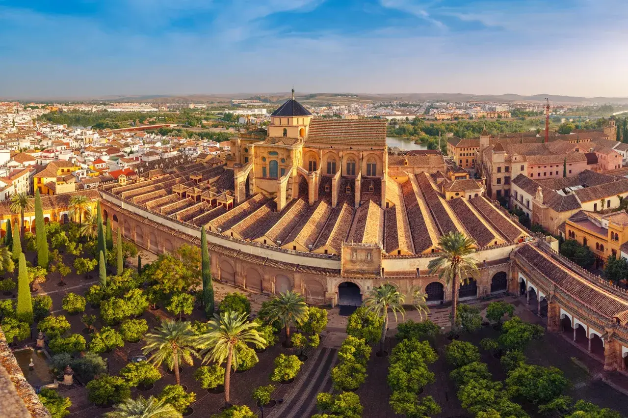 Vista aérea de la Mezquita-Catedral de Córdoba, uno de los monumentos de Córdoba más impresionantes, con su patio de naranjos y la ciudad al fondo.