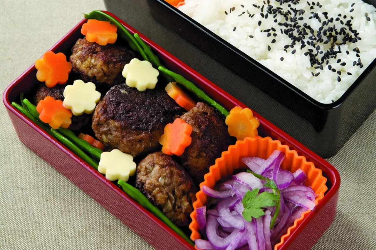 Hamburger bento with meatballs, star-shaped carrots, cheese, green beans, and pickled red onions.