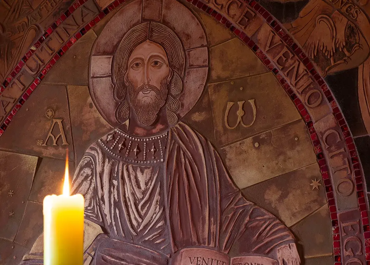 Płaskorzeźba Chrystusa z zapaloną świecą. Wokół napisy, w tym fragmenty nawiązujące do psalmów, np. psalm 99.