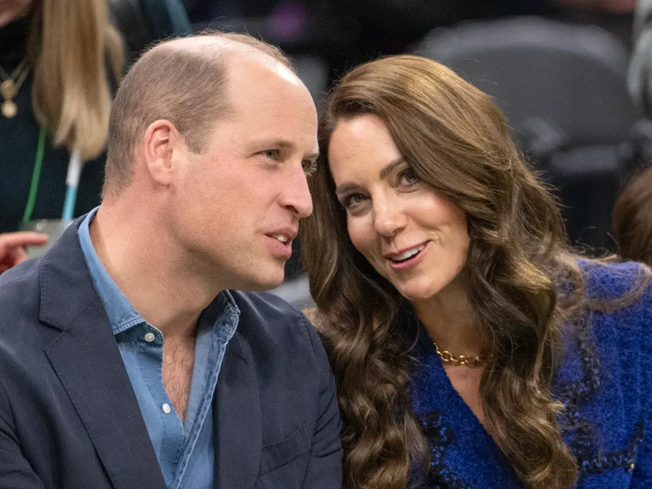 Księżna Kate w czwartej ciąży, uśmiechnięta, rozmawia z księciem Williamem.