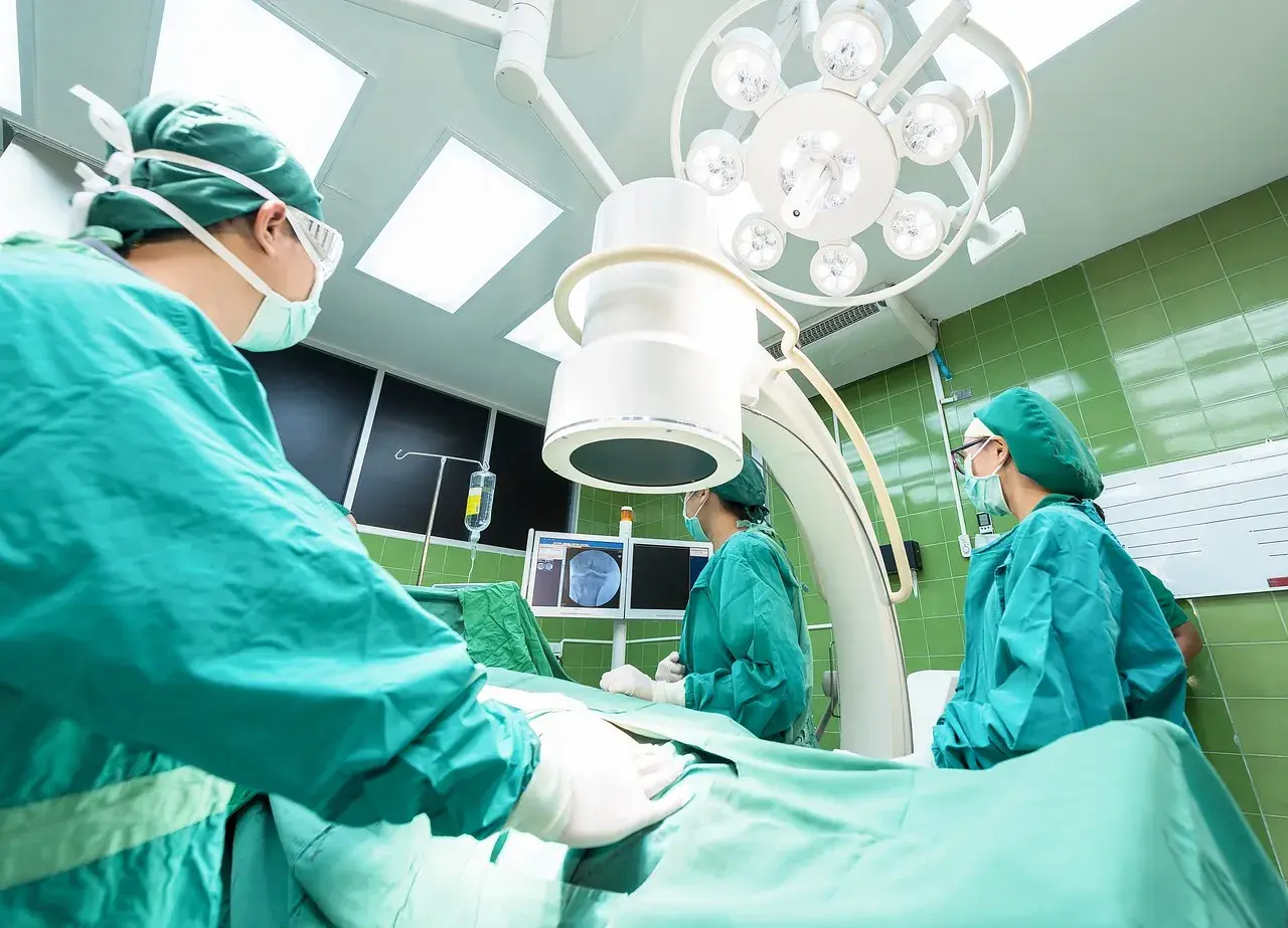 Chirurghi in sala operatoria, concentrati sul loro lavoro. La loro **responsabilità professionale** è evidente in ogni gesto.