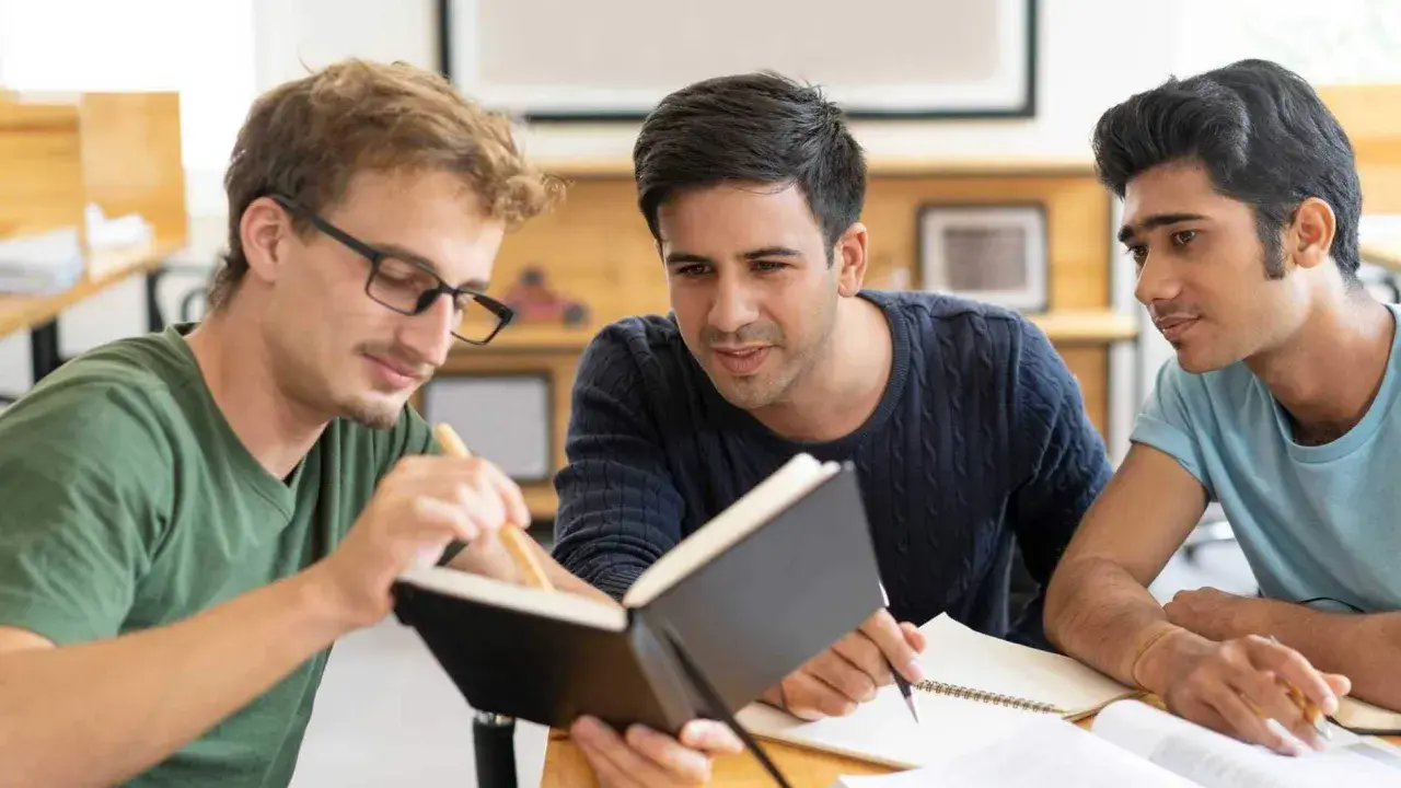 Tre studenti collaborano su un progetto, con un libro aperto. Il tempo per studiare è **enough quando si usa** con saggezza.