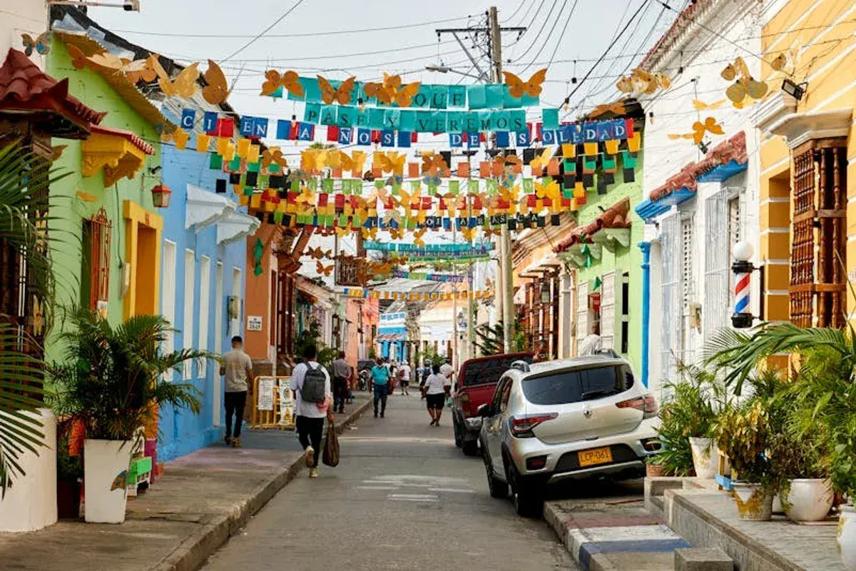 Bunte Häuser und Schmetterlingsgirlanden säumen eine Straße. Perfekt für die beste Reisezeit Curacao, um diese lebendige Atmosphäre zu genießen.