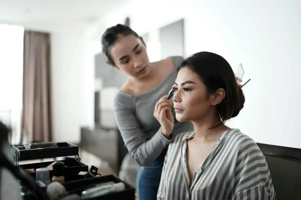 En makeupartist applicerar en silikonbaserad primer på en kvinna.