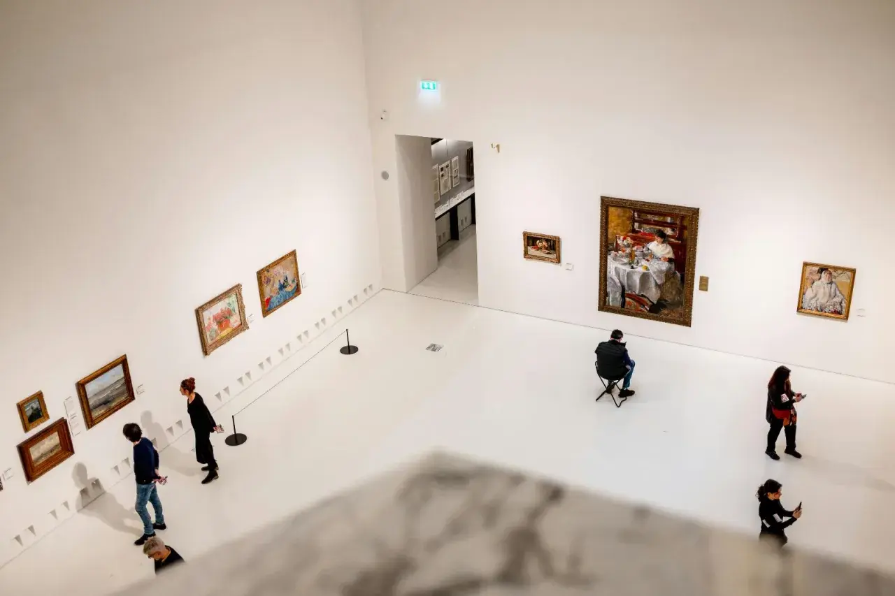 W galerii sztuki, gdzie dzieła wiszą na białych ścianach, ludzie kontemplują obrazy. To czysta sztuka dla sztuki, chwila zadumy nad pięknem.