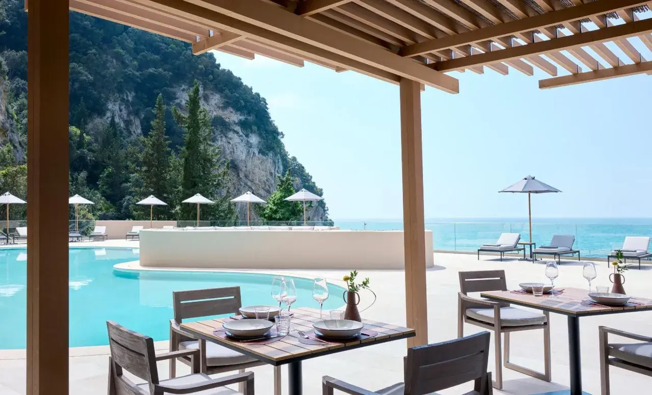 Ein gedeckter Tisch am Pool mit Blick aufs Meer. Der alkyna lifestyle beach resort bietet pure Entspannung.