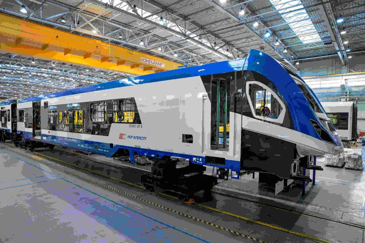 Nowe, niebiesko-białe zespoły trakcyjne PKP Intercity w hali produkcyjnej.