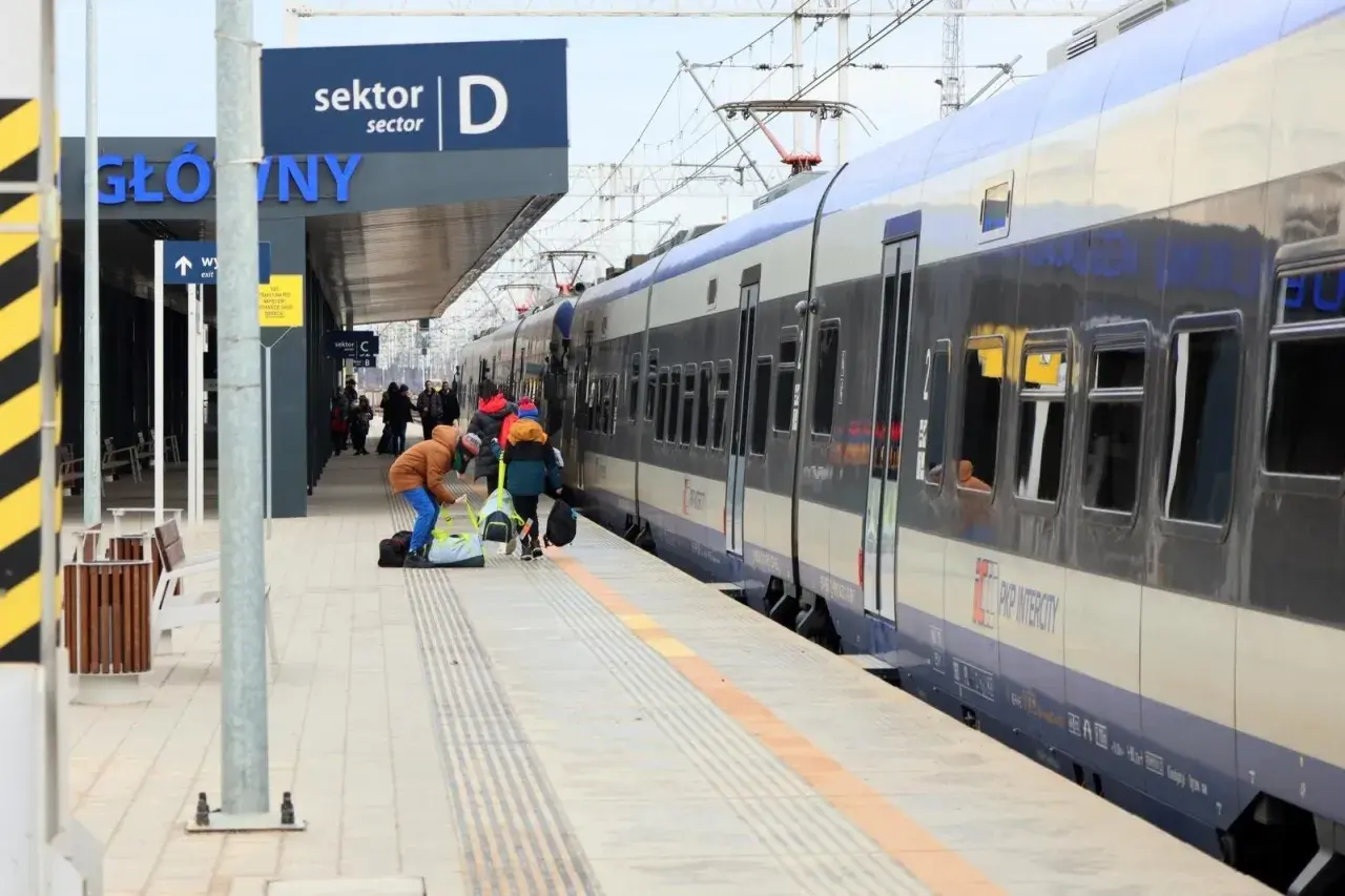 Praca ustawiacz kolejowy na dworcu. Ludzie z bagażami czekają na pociąg PKP Intercity.