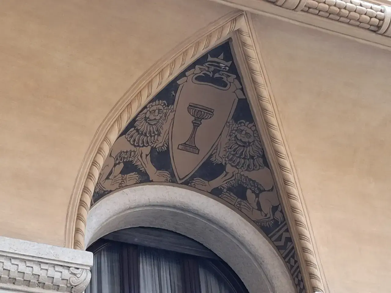 Affresco con leoni rampanti e calice, dettaglio architettonico del quartiere Coppedè.
