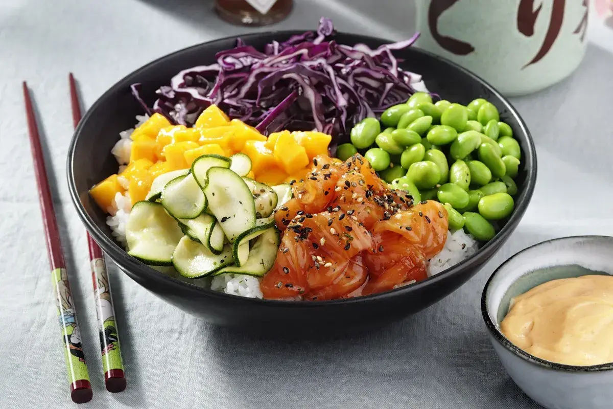 En färgglad poke bowl med lax, mango, gurka, edamamebönor och rödkål. En perfekt och hälsosam måltid.