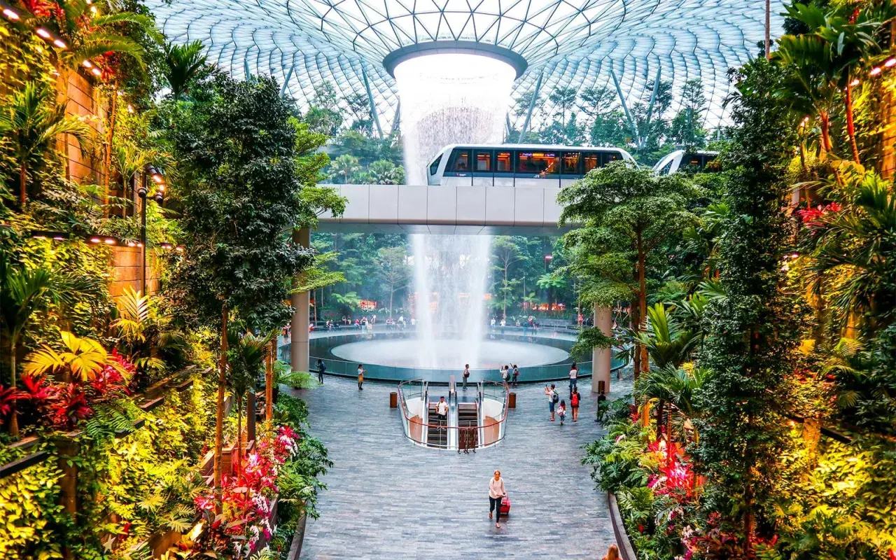 Im **Singapore Flughafen** erwartet Reisende eine üppige Oase mit einem beeindruckenden Wasserfall und einer Monorail, die durch tropische Vegetation fährt.