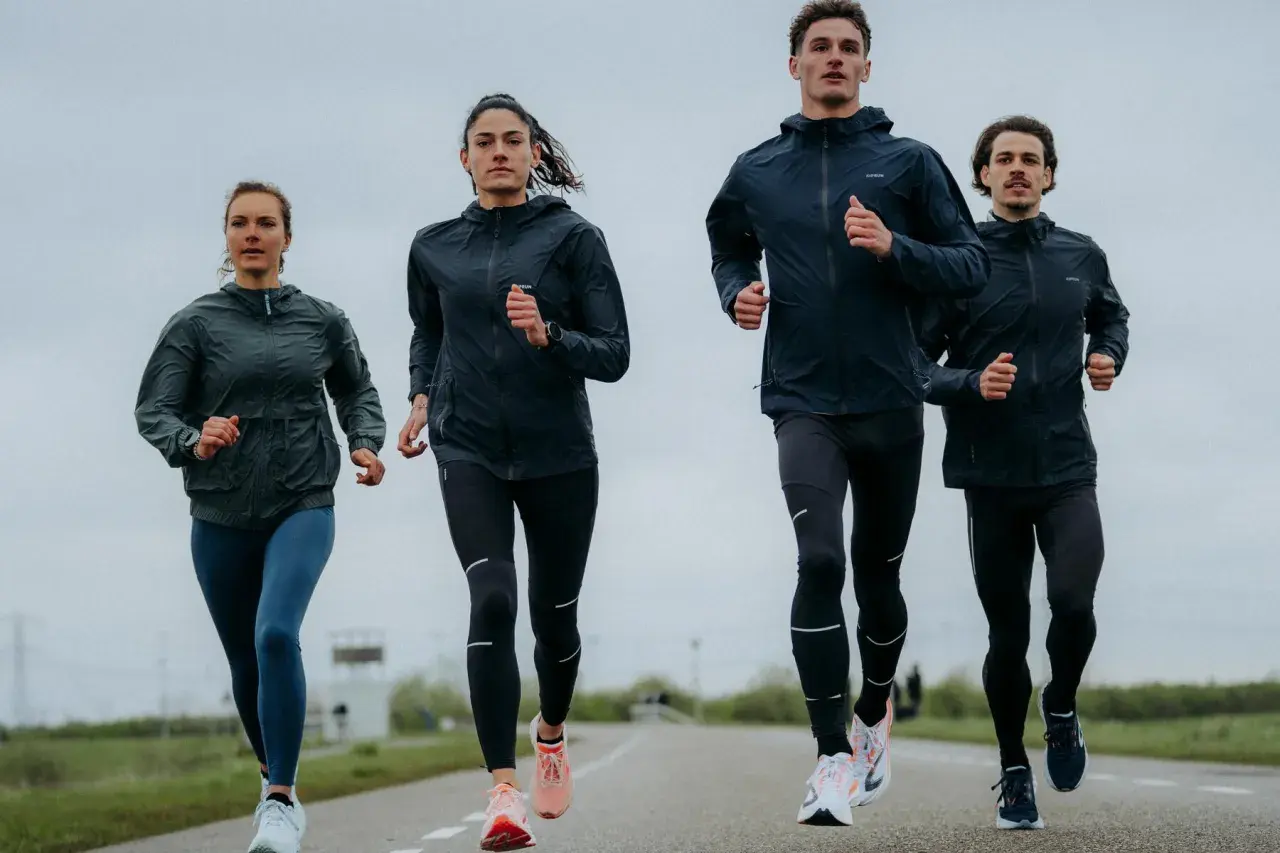 Cztery osoby biegną po drodze, ubrani w sportowe kurtki i legginsy. Wyglądają, jakby właśnie odkryli, kiedy wynaleziono bieganie.