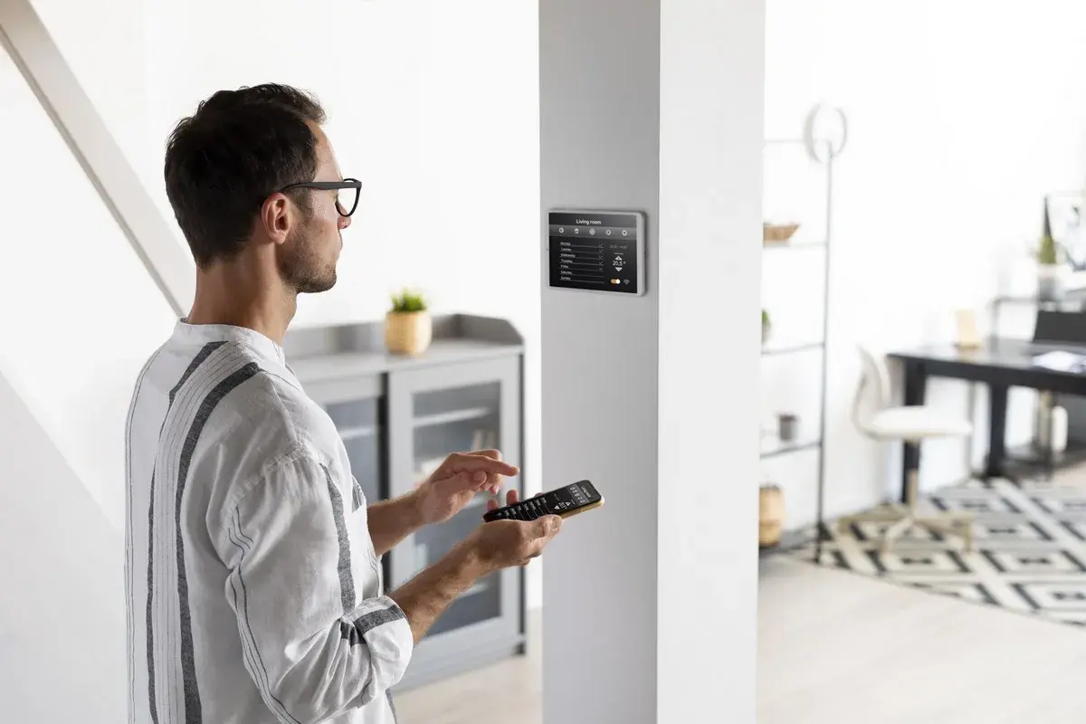 Un homme utilise une télécommande pour installer une alarme sur un écran tactile mural.