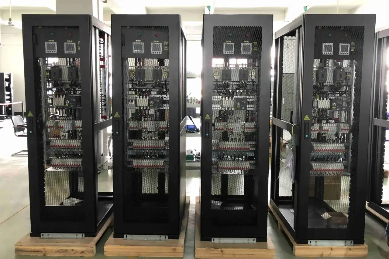 Cuatro racks negros con equipos electrónicos visibles a través de rejillas, parte de un cuarto de comunicaciones.