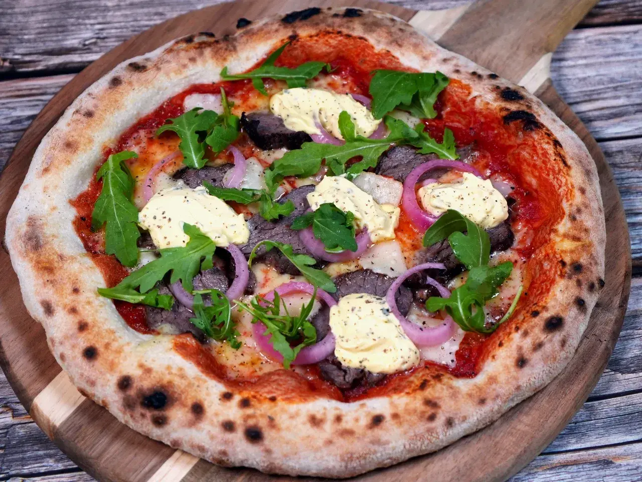 En läcker pizza med oxfilé, röd lök, ruccola och en krämig sås. Perfekt för en mysig kväll.